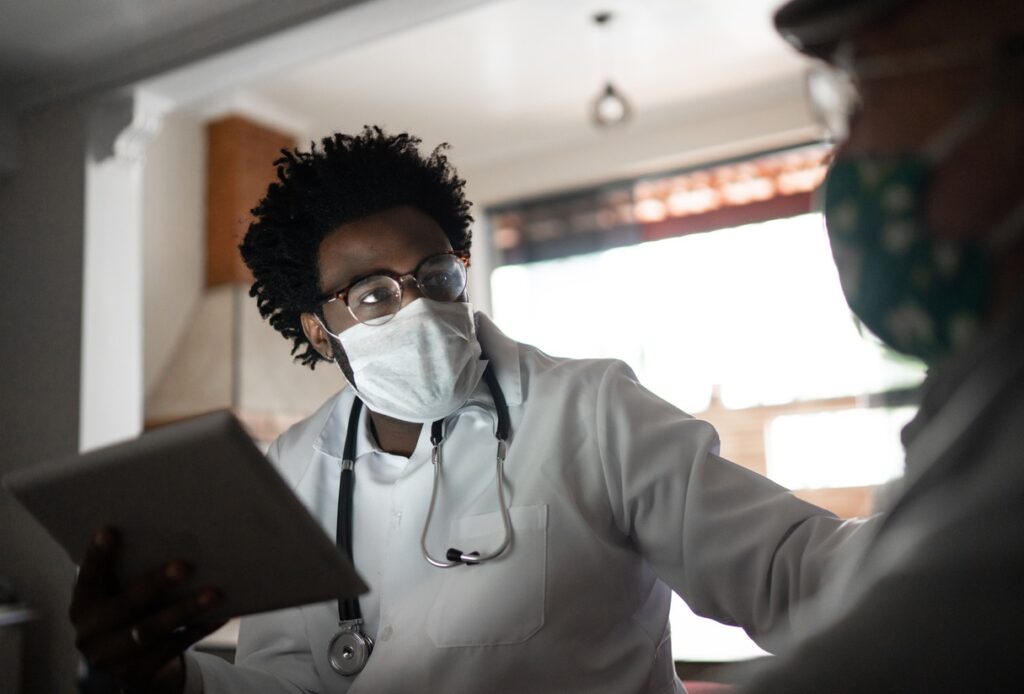 photo of a doctor wearing a facemask and working hard