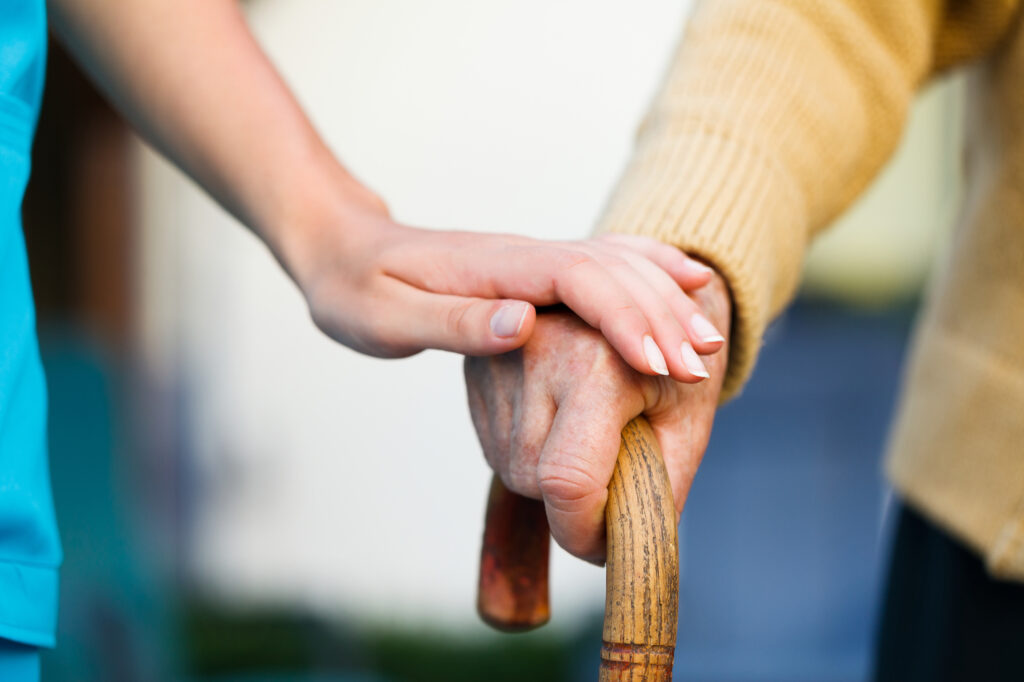 Photo of a doctor holding a senior patient hand.
