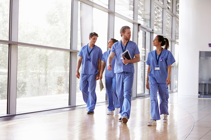 Photo of healthcare workers in a hospital walking.