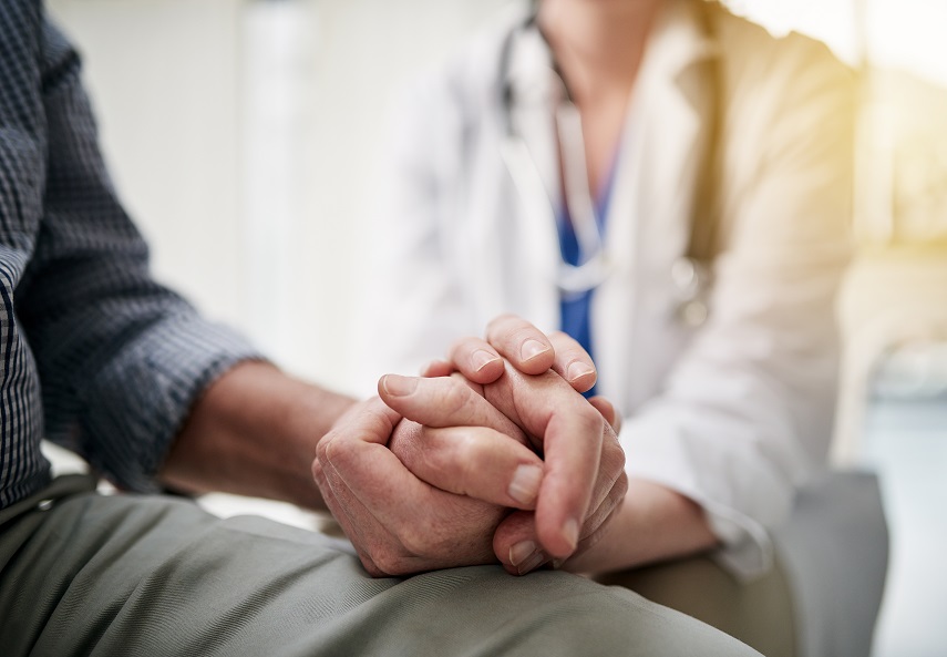 photo of a doctor holding a patient's hand